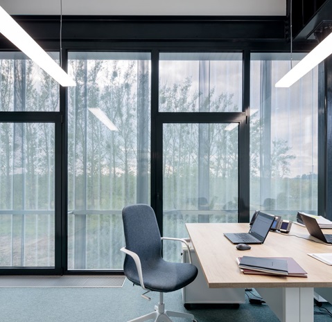 Widok z okna Prime Construction przez perforowane profile elewacyjne Ruukki